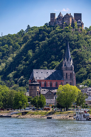 Oberwesel Germany: Liebfrauenkirche Church in foreground: Schonburg Castle on hill in background (built around 911-1166)- restored late 19th century- currently a hotel: (Viking maintanace bo